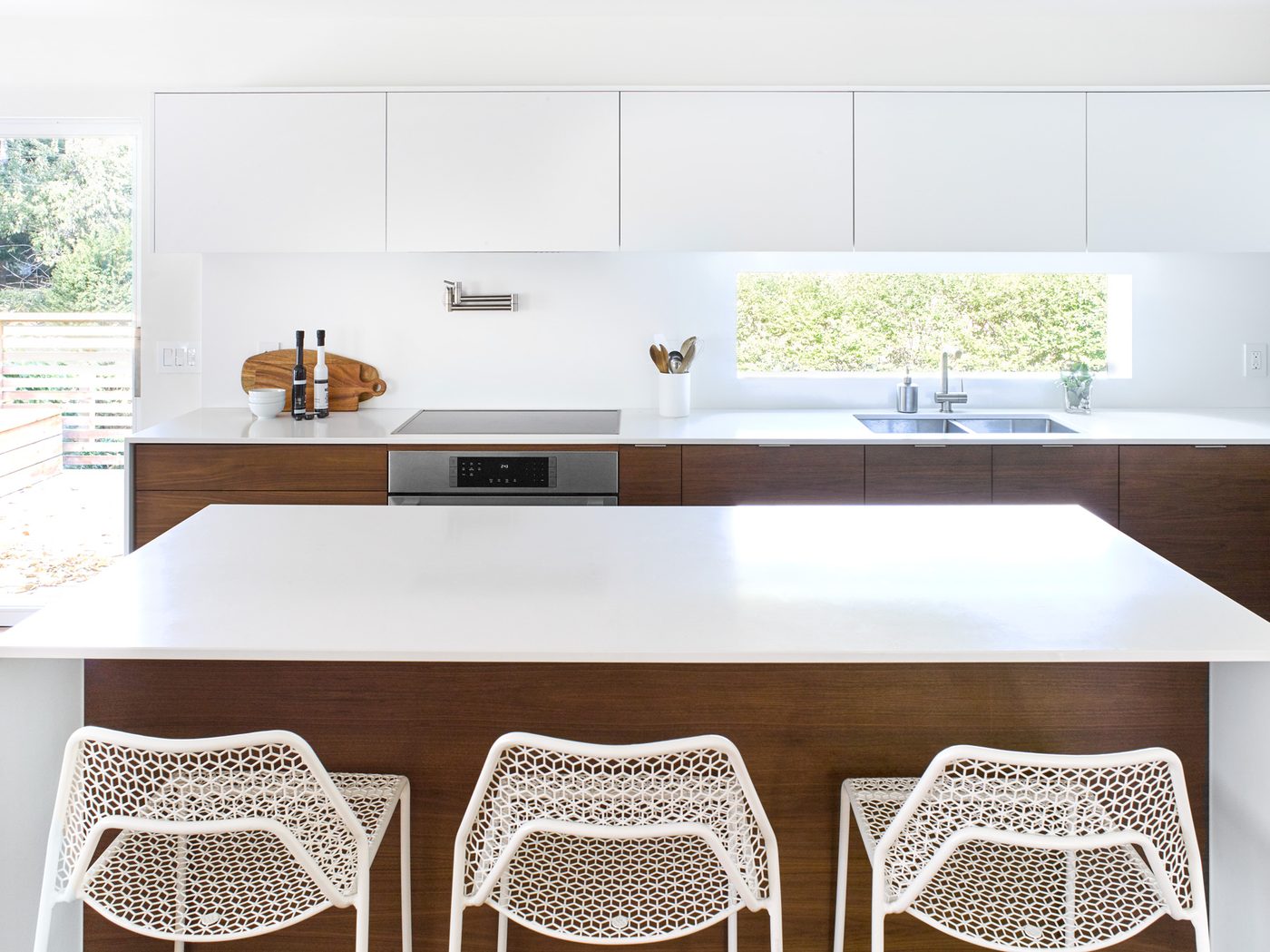 White and walnut modern kitchen with island and bar seating